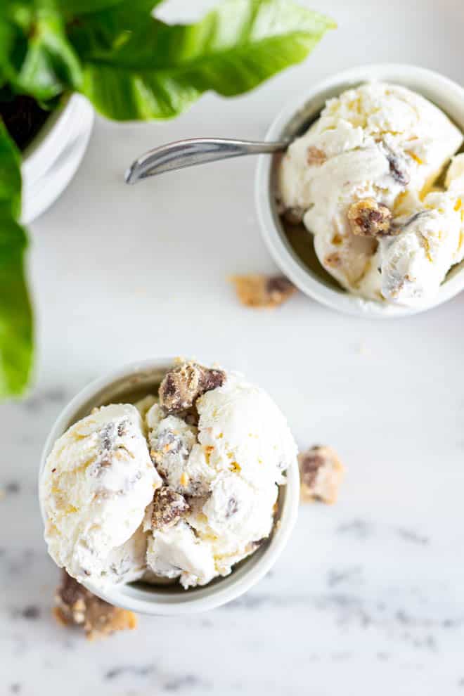 two scoops of cookie dough ice cream in two separate bowls sitting on a table