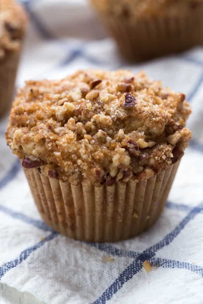 one large coffee cake muffin sitting on a blue check napkin