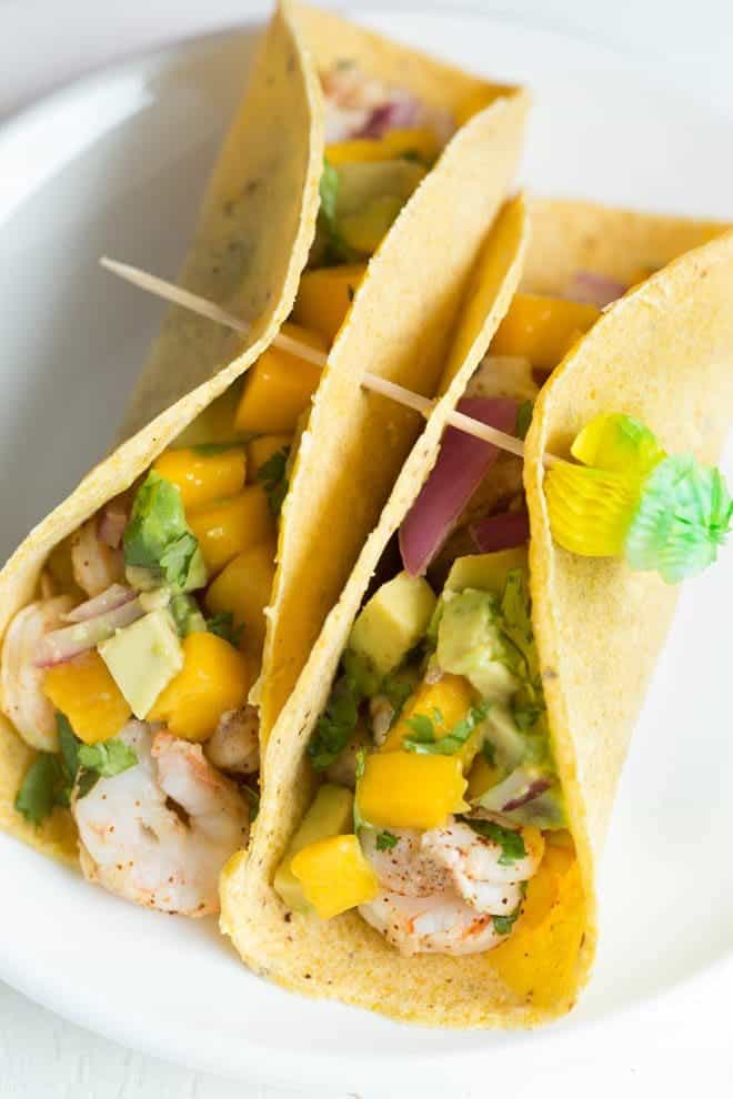 Shrimp Tacos with Mango Avocado Salsa are a quick, fresh and easy meal for lunch or dinner! Lightly seasoned grilled shrimp are topped with a homemade mango avocado salsa to create a meal kids and adults will love.