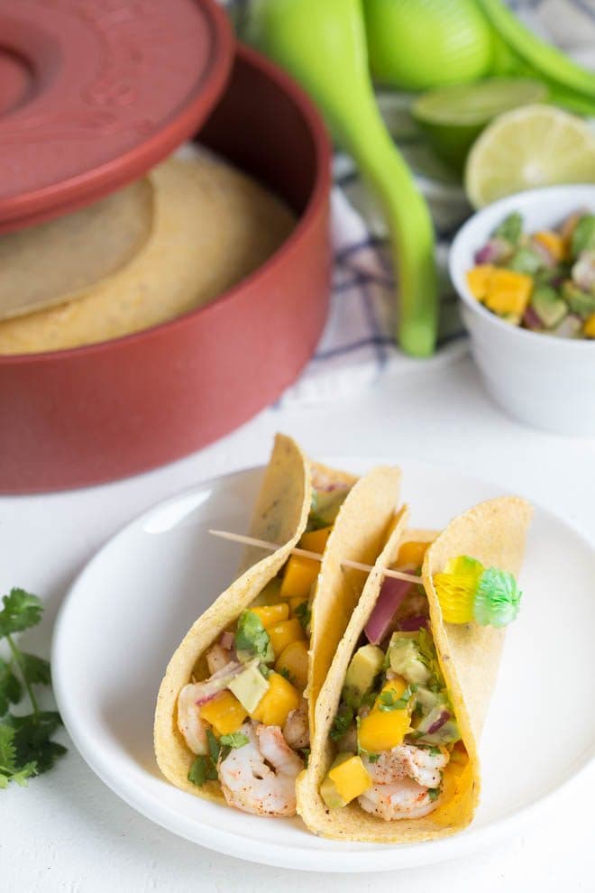 Shrimp Tacos with Mango Avocado Salsa are a quick, fresh and easy meal for lunch or dinner! Lightly seasoned grilled shrimp are topped with a homemade mango avocado salsa to create a meal kids and adults will love.