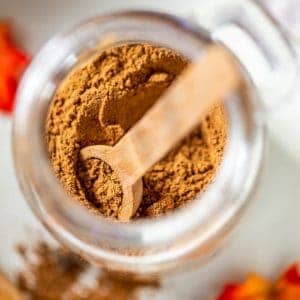 scooping out pumpkin pie spice from a jar