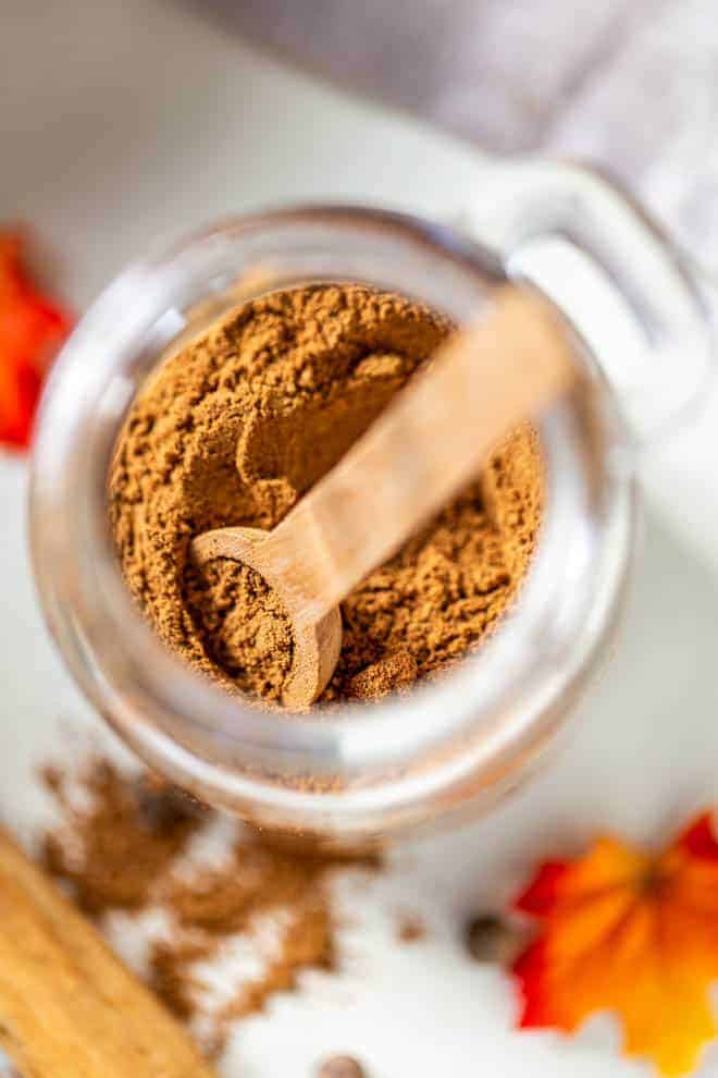 scooping out pumpkin pie spice from a jar