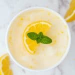 a container of lemon sorbet with a sprig of mint on top
