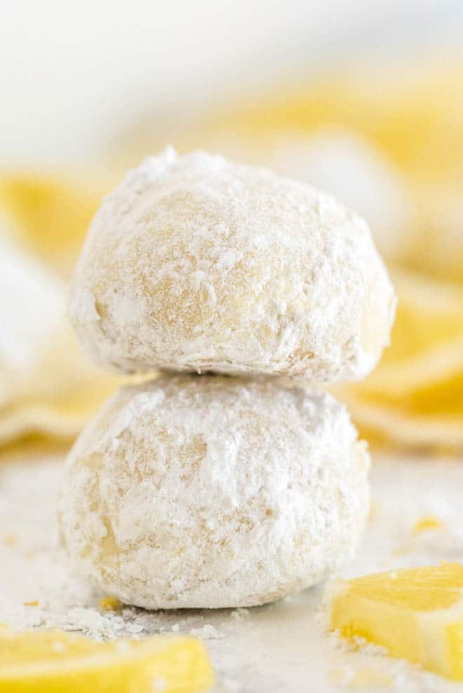 two lemon tea cookies stacked on top of each other with a yellow napkin in the background