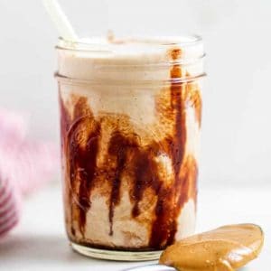 Glass mug with peanut butter smoothie.
