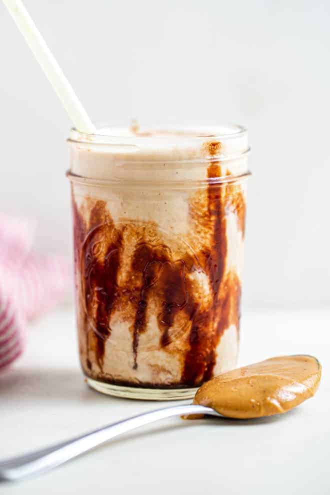 Glass mug with peanut butter smoothie.