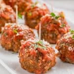 mozzarella stuffed meatballs sitting on a white place