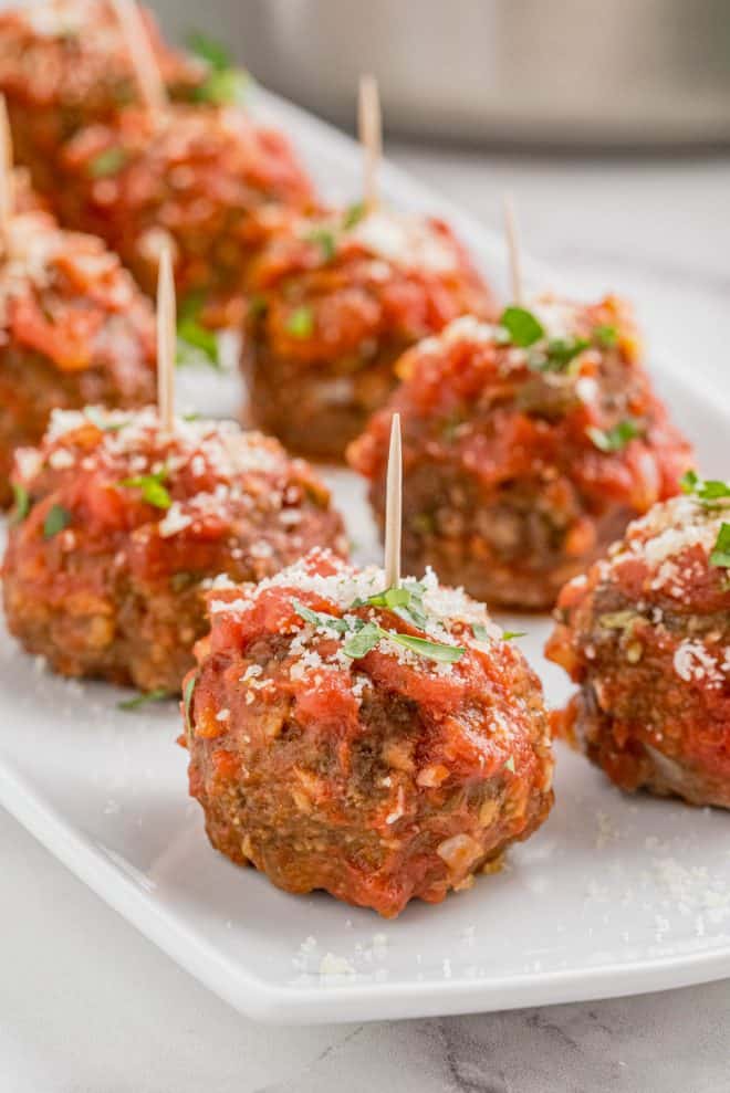 mozzarella stuffed meatballs sitting on a white place