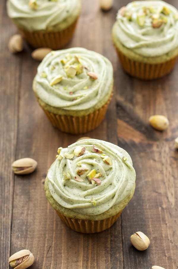 matcha cupcakes sitting on a wooden tabletop