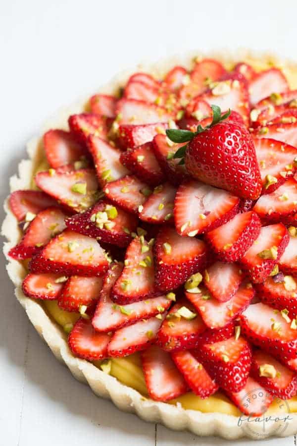 Strawberry Pistachio Cardamom Tart is made with a lemon coconut crust, cardamom pastry cream, fresh strawberries and pistachios! It is gluten free and dairy free too!