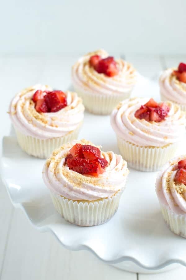 Strawberry Cheesecake Cupcakes are a delectable dessert made with vanilla cupcakes stuffed with cream cheese filling and topped with strawberry buttercream and fresh berries!
