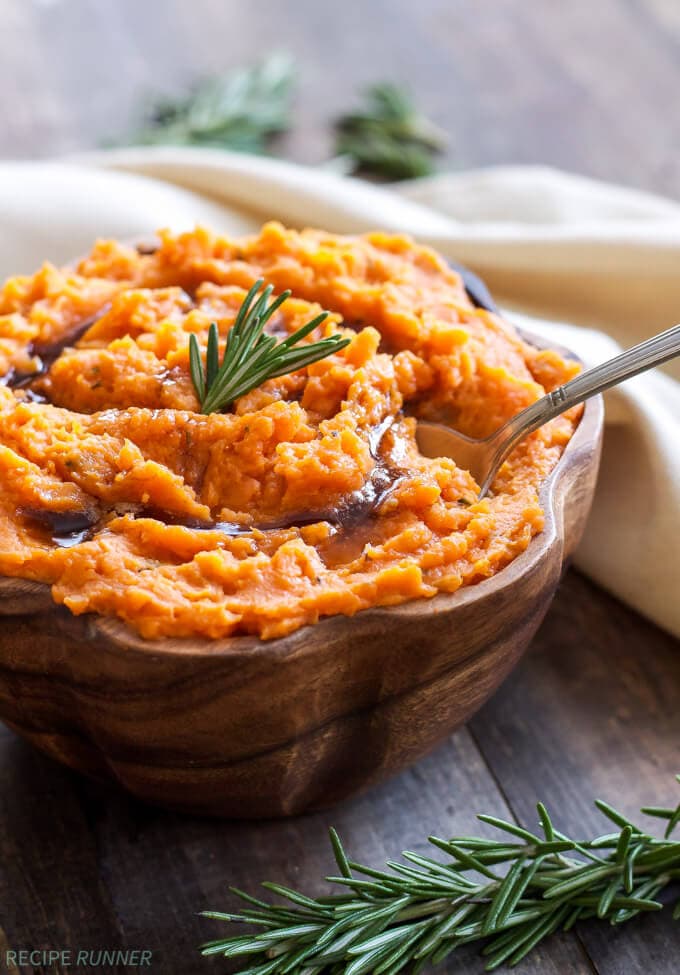 a wooden bowl filled with mashed sweet potatoes with brown butter and rosemary