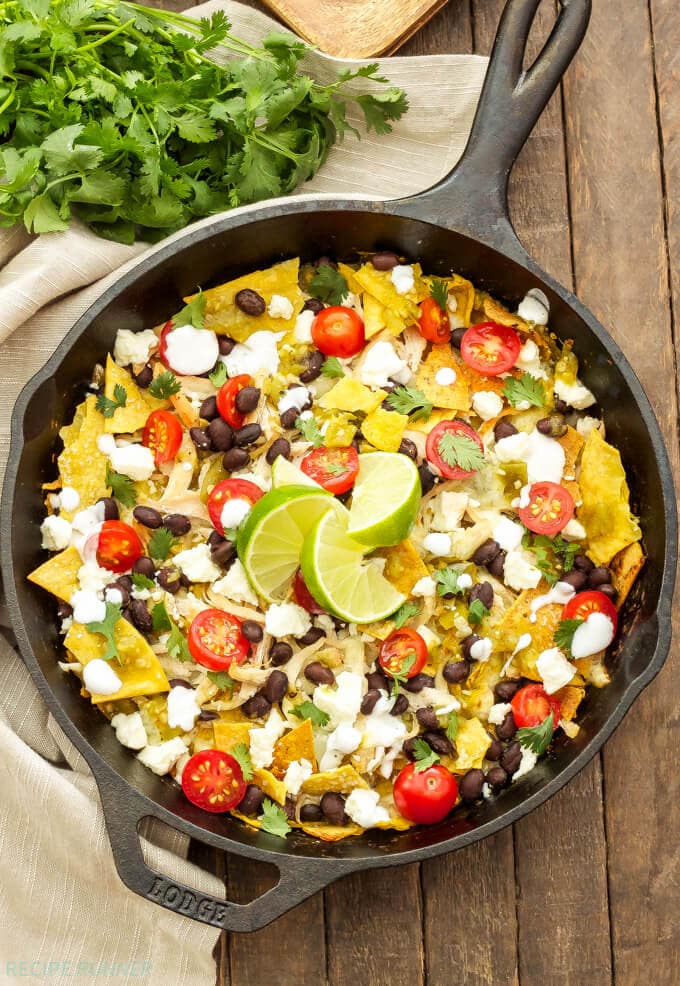 an entire skillet filled which tortillas, cheese, chicken and chilaquiles toppings