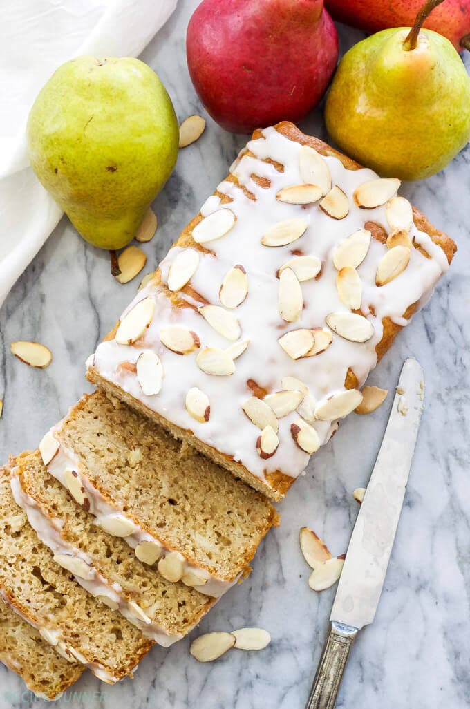 pear bread with almond glaze on a countertop with a knife