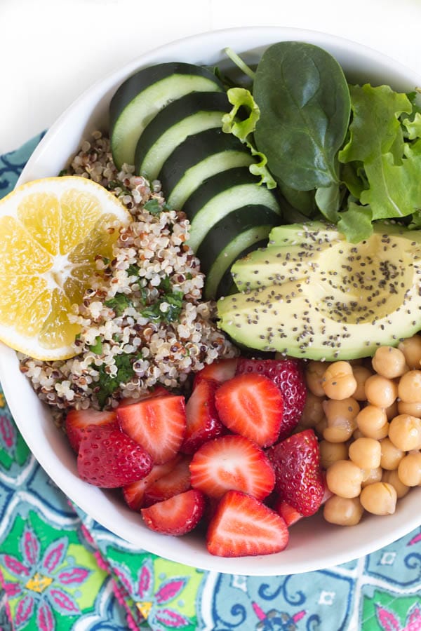 Nourish yourself with a berry green Buddha bowl packed with protein, fresh greens, vegetables, berries and topped with a creamy lemon avocado kale mint dressing!