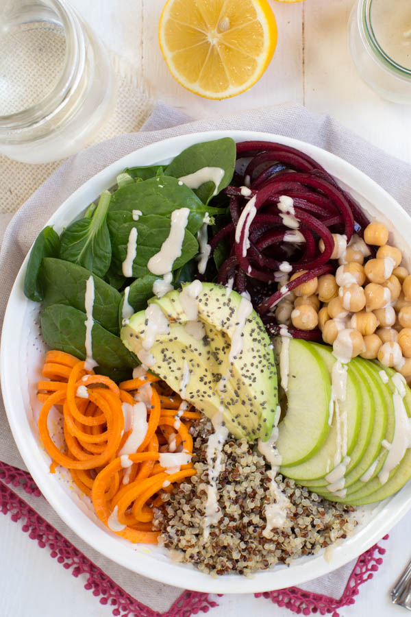Harvest Buddha Bowl with Lemon Tahini Dressing is made with fresh spiralized beet and sweet potato noodles, spiralized apple, chickpeas, spinach and more! Pack this bowl for lunch to fuel up for the day.