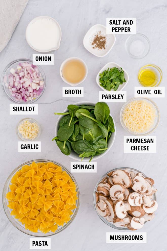 ingredients for spinach mushroom pasta on white tabletop