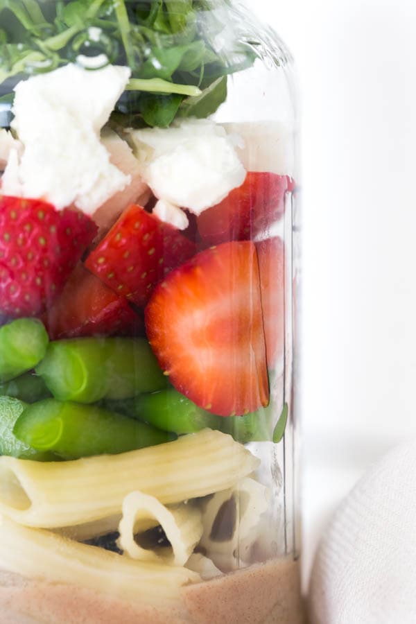 Six ingredients are layered in a mason jar to create a fresh and flavorful Spring Green Mason Jar Salad with Strawberries! Pack the mason jar for on-the-go or enjoy an easy lunch at home.