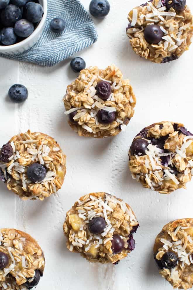 baked oatmeal cups with blueberries sitting on a white tabletop