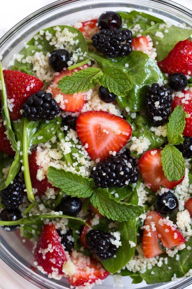 Triple Berry Couscous Salad combines couscous with fresh spinach, strawberries, blueberries and blackberries. Drizzle the homemade honey lime mint dressing over the salad to create a light and flavorful addition to any meal!