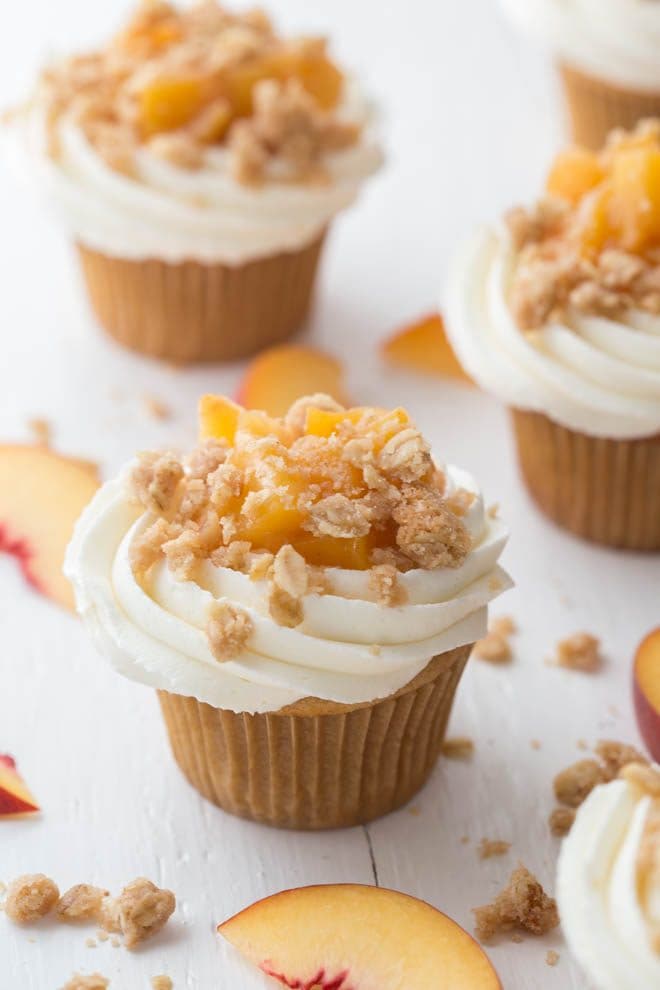 Peach Pie Cupcakes are a fun twist on a classic dessert! Light vanilla bean cupcakes are topped with homemade peach pie filling, vanilla buttercream frosting and baked crumb topping. 