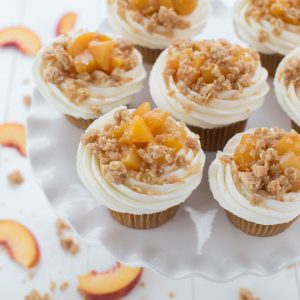Peach Pie Cupcakes are a fun twist on a classic dessert! Light vanilla bean cupcakes are topped with homemade peach pie filling, vanilla buttercream frosting and baked crumb topping.