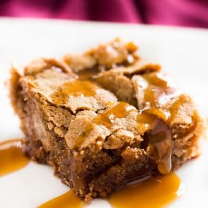 Slice of caramel apple cake on a plate with homemade caramel sauce drizzle