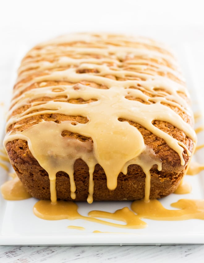 a loaf of maple pumpkin bread with maple glaze drizzled on top