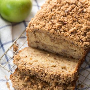 Greek Yogurt Apple Spice Bread is lightened up with Greek yogurt and apple sauce to create a delectable treat that the entire family will love! The bread is made with fresh apples and then topped with a pecan crumble topping.