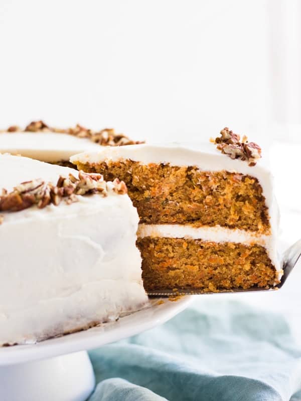 a slice of two layer carrot cake being pulled out from the cake