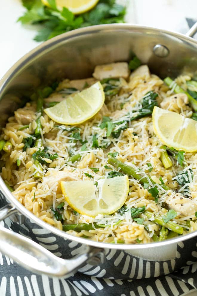 creamy orzo pasta in a skillet with lemon spices on top