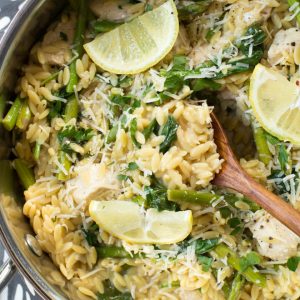 skillet with creamy orzo pasta and chicken, asparagus and spinach