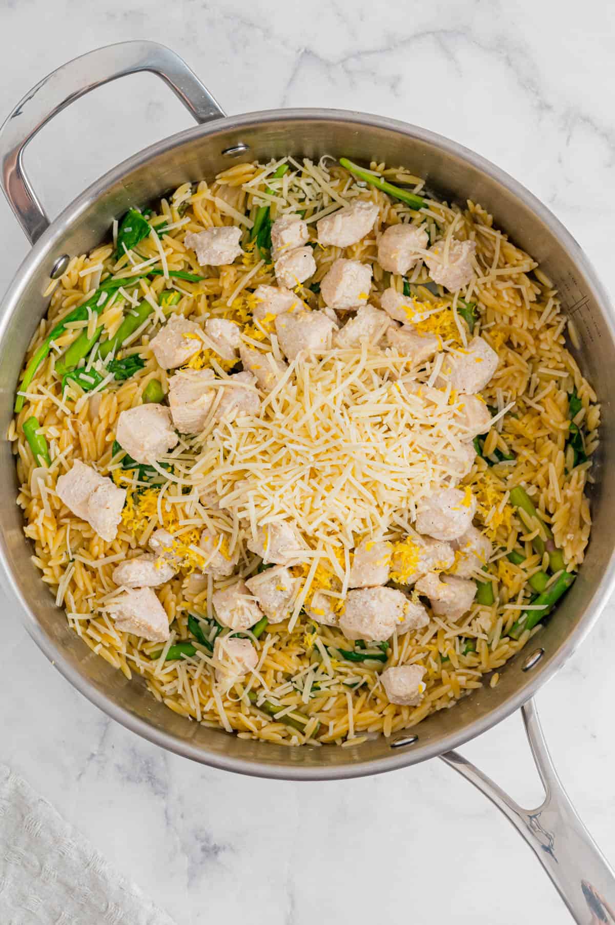 cooked orzo pasta with chicken and cheese on top
