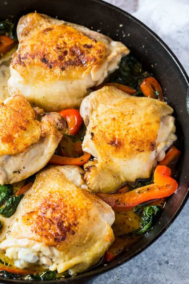 Creamy Chicken Skillet with Red Pepper and Greens is a simple meal made in one skillet! The meal cooks in under 30 minutes and is made with a creamy garlic basil sauce. #skillet #onepot #dinner #chicken #recipe
