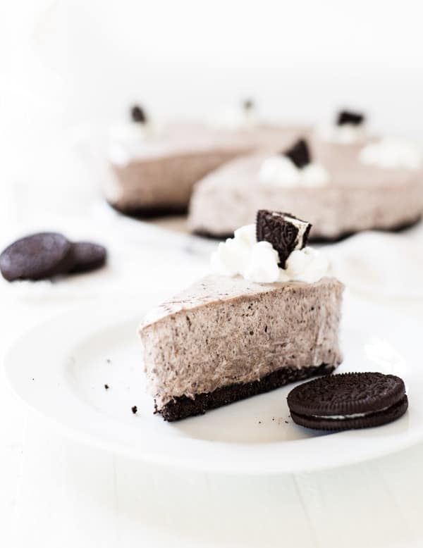 One slice of oreo cheesecake on a white plate.