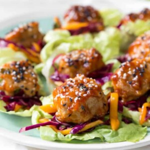 Wrap saucy chicken meatballs and fresh mango slaw with crunchy butter lettuce to create these Asian Chicken Meatball Lettuce Wraps with Mango Slaw! Enjoy them for lunch, dinner or as an appetizer. #chicken #meatballs #dinner #lunch #appetizer #asian #healthy #recipe #mango