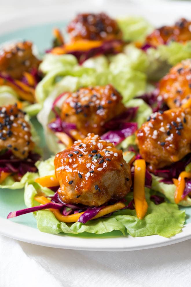 Wrap saucy chicken meatballs and fresh mango slaw with crunchy butter lettuce to create these Asian Chicken Meatball Lettuce Wraps with Mango Slaw! Enjoy them for lunch, dinner or as an appetizer. #chicken #meatballs #dinner #lunch #appetizer #asian #healthy #recipe #lowcarb