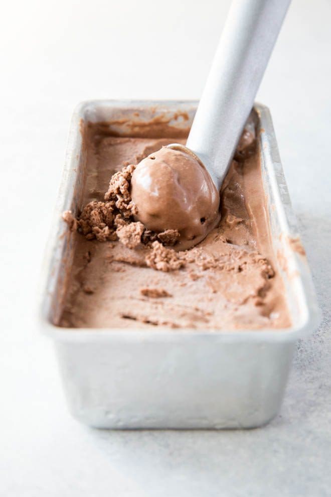 chocolate coconut milk ice cream in a container with a scoop taken out