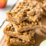 a stack of apple crumb bars sitting on a cutting board