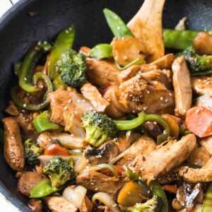 Garlic Sesame Chicken Stir Fry is an easy meal that’s on the table in 30 minutes or less and boasts an authentic Chinese stir-fry flavor! Skip take out to make this healthier stir fry at home. #sesame #chicken #stirfry #dinner #recipe #skillet