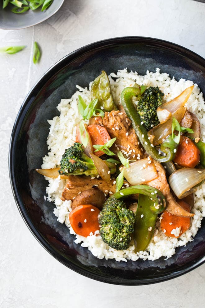 Garlic Sesame Chicken Stir Fry is an easy meal that’s on the table in 30 minutes or less and boasts an authentic Chinese stir-fry flavor! Skip take out to make this healthier stir fry at home. #sesame #chicken #stirfry #dinner #recipe