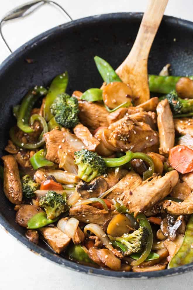 Garlic Sesame Chicken Stir Fry is an easy meal that’s on the table in 30 minutes or less and boasts an authentic Chinese stir-fry flavor! Skip take out to make this healthier stir fry at home. #sesame #chicken #stirfry #dinner #recipe #skillet 