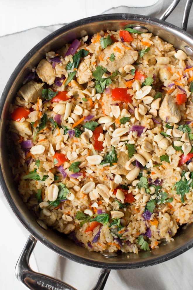 Thai Chicken Peanut Rice Skillet is an easy one pot meal that cooks in less than 30 minutes! It's packed with red bell peppers, carrots, cabbage, baby bok choy, chicken, rice and a creamy peanut sauce. #chicken #peanut #skillet #dinner #weeknight #meal #rice