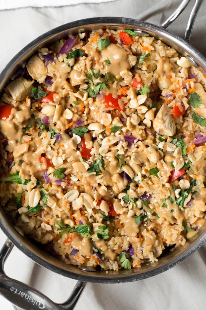 Thai Chicken Peanut Rice Skillet is an easy one pot meal that cooks in less than 30 minutes! It's packed with red bell peppers, carrots, cabbage, baby bok choy, chicken, rice and a creamy peanut sauce. #chicken #peanut #skillet #dinner #weeknight #meal #30minutes