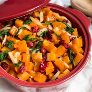 Combine a few simple ingredients together to create this Roasted Butternut Squash with Cranberries, Greens and Apples! The side dish is naturally gluten free and paleo. It's the perfect side dish for dinner or holiday parties. #roasted #butternutsquash #sidedish #cranberries #thanksgiving #healthy #paleo #glutenfree #recipe