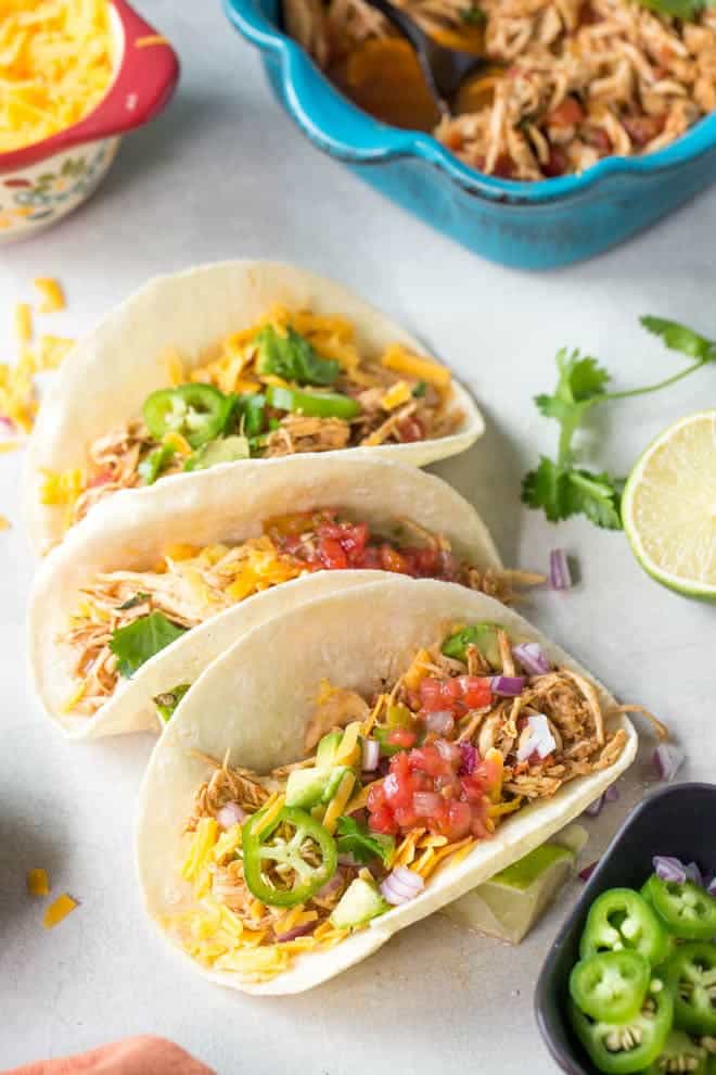 Easy shredded chicken tacos made in the slow cooker or crockpot with only a few ingredients! Create a dinner the entire family will love. #family #dinner #chicken #tacos #recipe #healthy