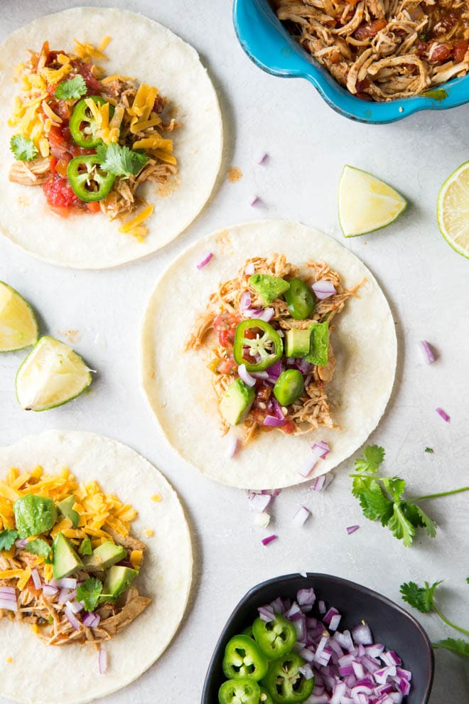 Shredded Chicken Tacos are made in the crockpot for an easy weeknight meal! Made from only a few ingredients, the shredded chicken is perfect for tacos or burrito bowls. #shredded #chicken #tacos #burrito #bowls #mealprep #dinner #recipe