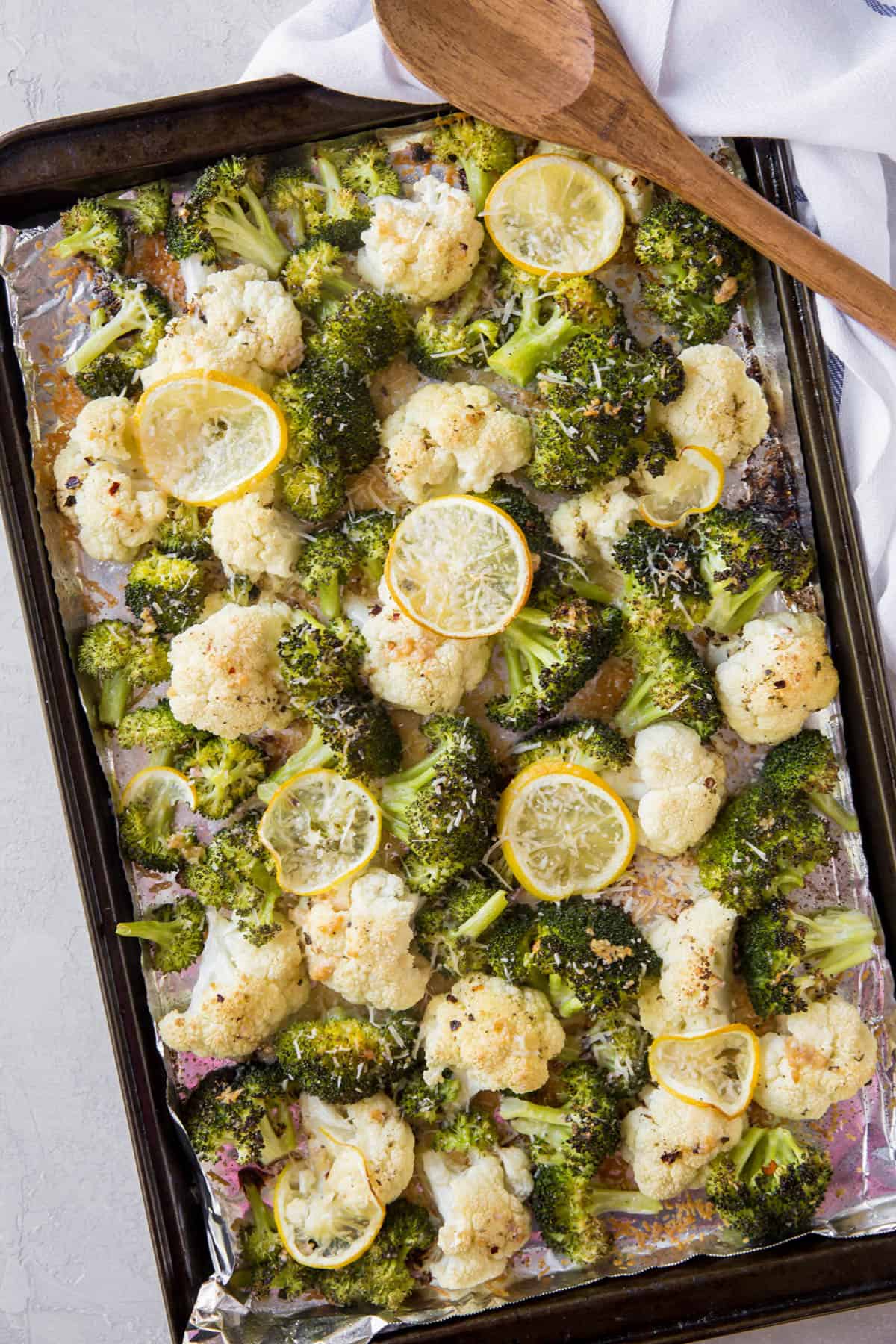 roasted broccoli and cauliflower on a sheet pan after roasting in the oven.