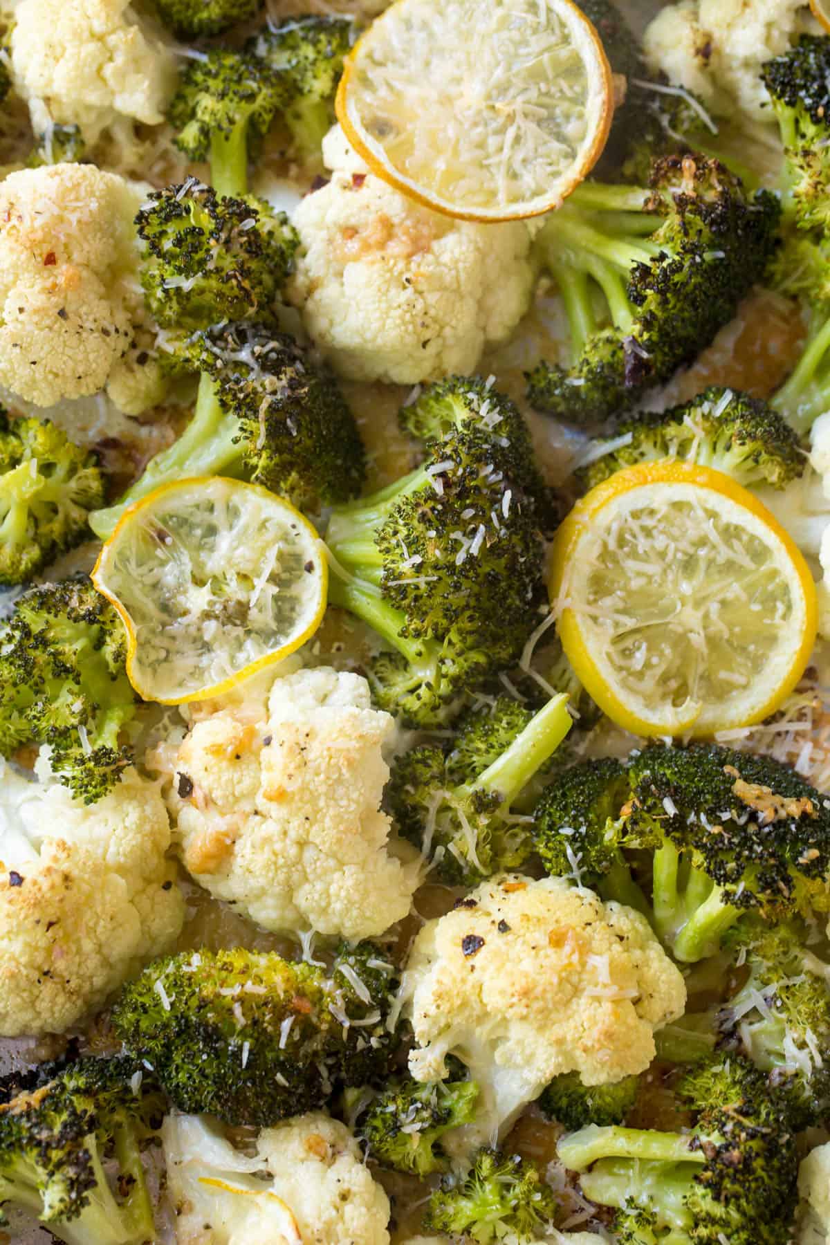 Cooked broccoli and cauliflower with lemon slices on top.