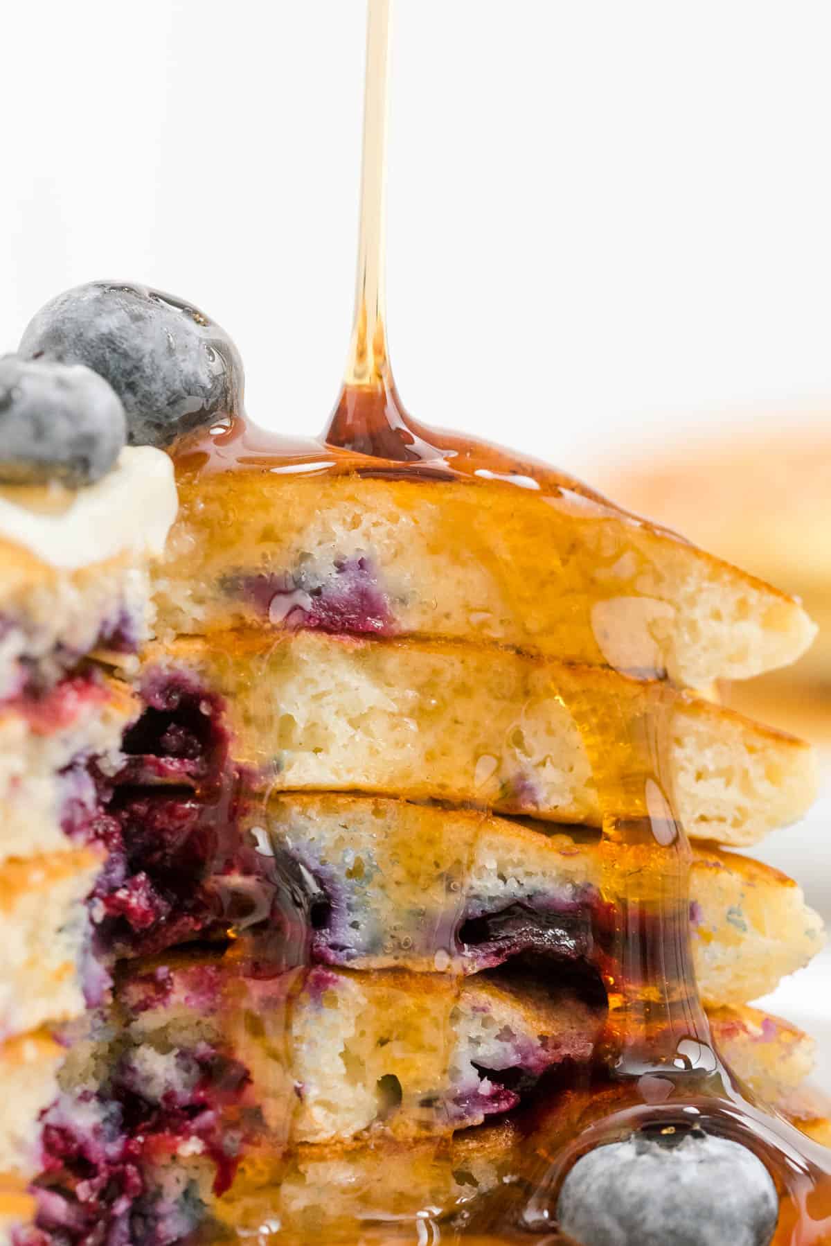 a cut pieces of blueberry buttermilk pancakes with maple syrup on top